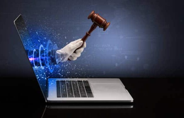 Hand with hammer coming out of a laptop with sparkling effects Hand with hammer coming out of a laptop with sparkling effects